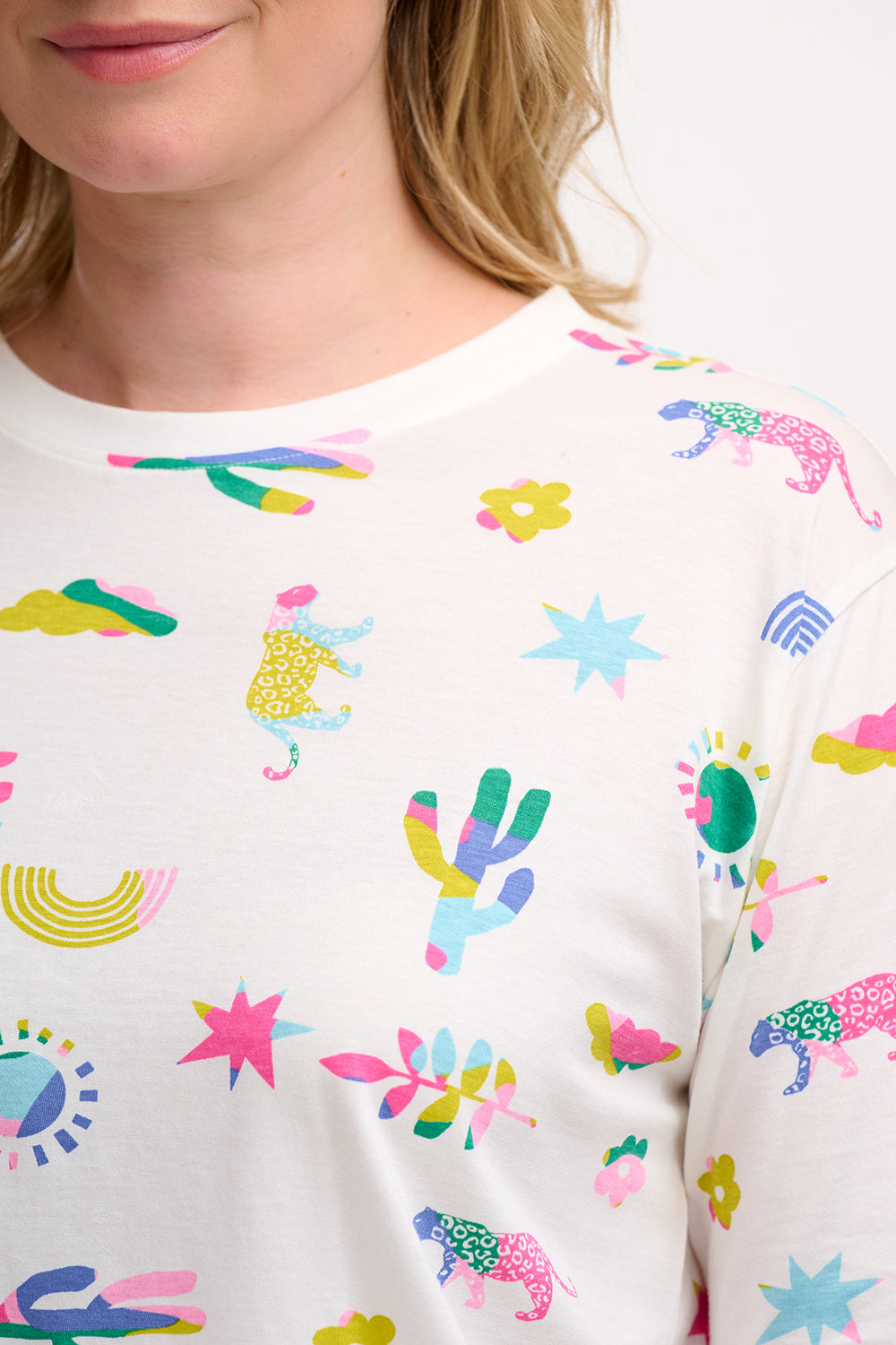 An off-white Kinsley Relaxed T-shirt with a round neck and short sleeves, featuring a colorful floral and animal pattern.