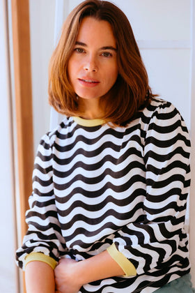 Model wearing Black and white striped sweater with yellow accents on a white background