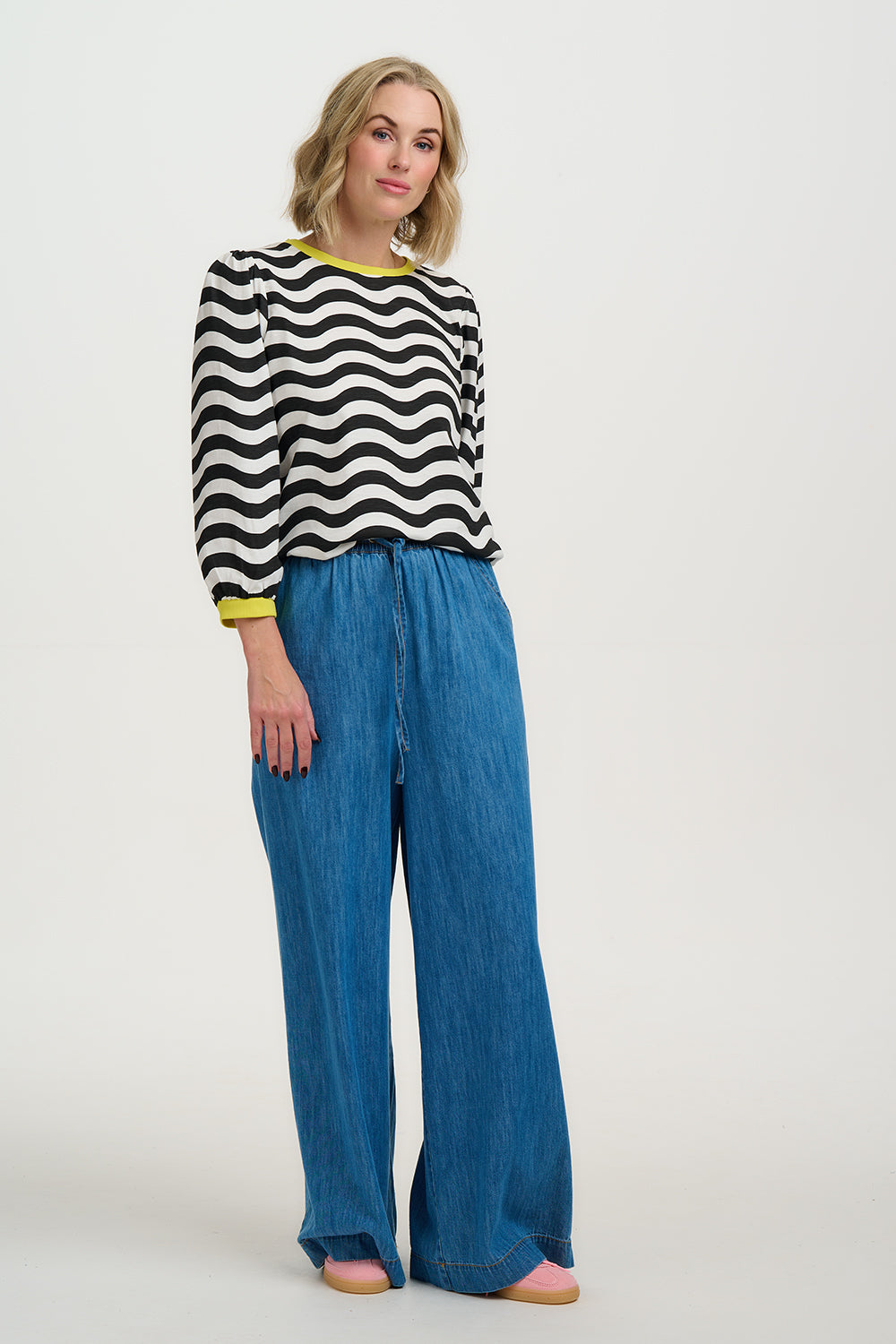 Model wearing Black and white striped sweater with yellow accents on a white background