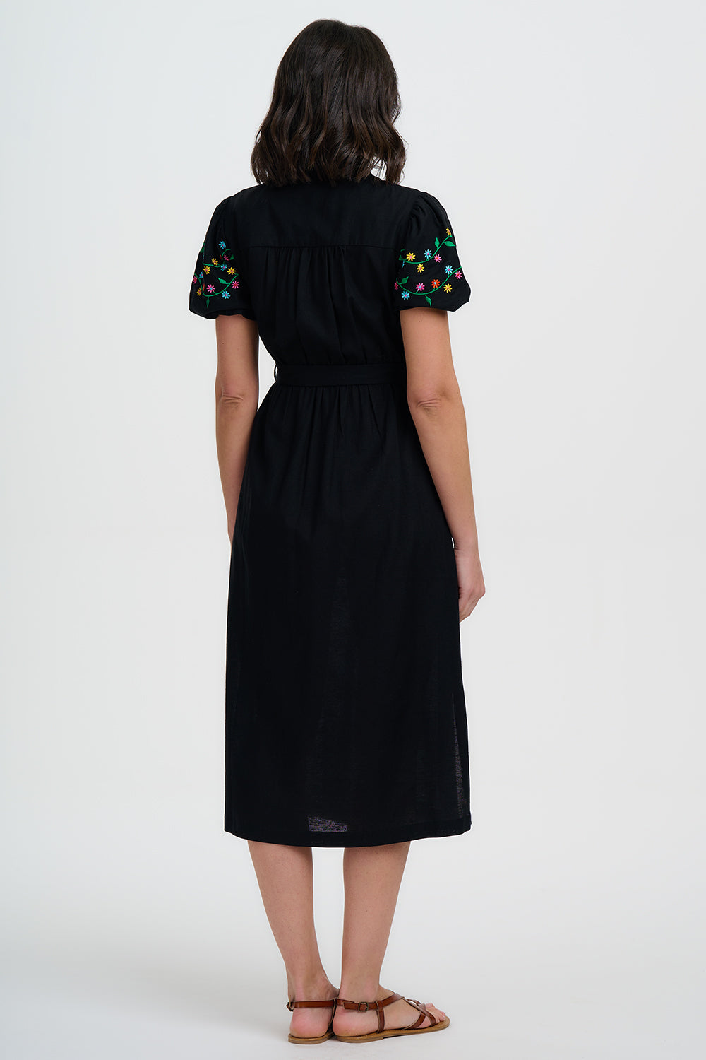 Black dress with colorful sleeves worn by a person on a white background