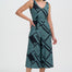 Woman wearing a green and black patterned dress on a white background