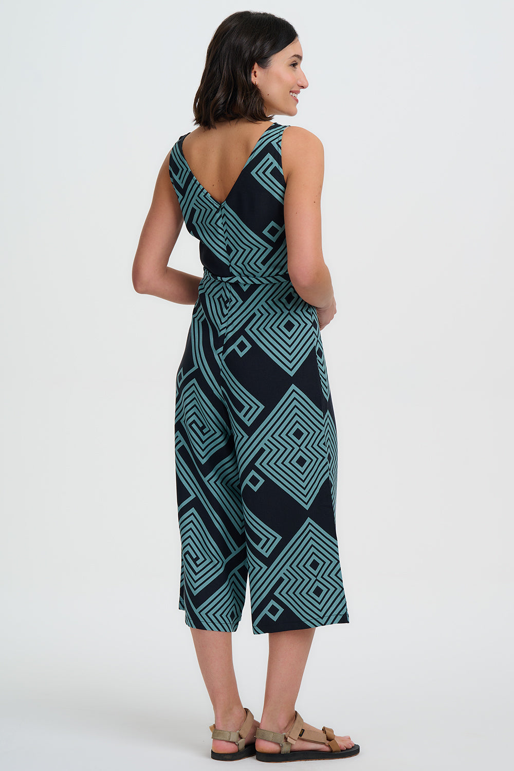 Woman wearing a black and teal patterned dress on a white background