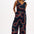 A black jumpsuit with a geometric pattern featuring colorful lines.