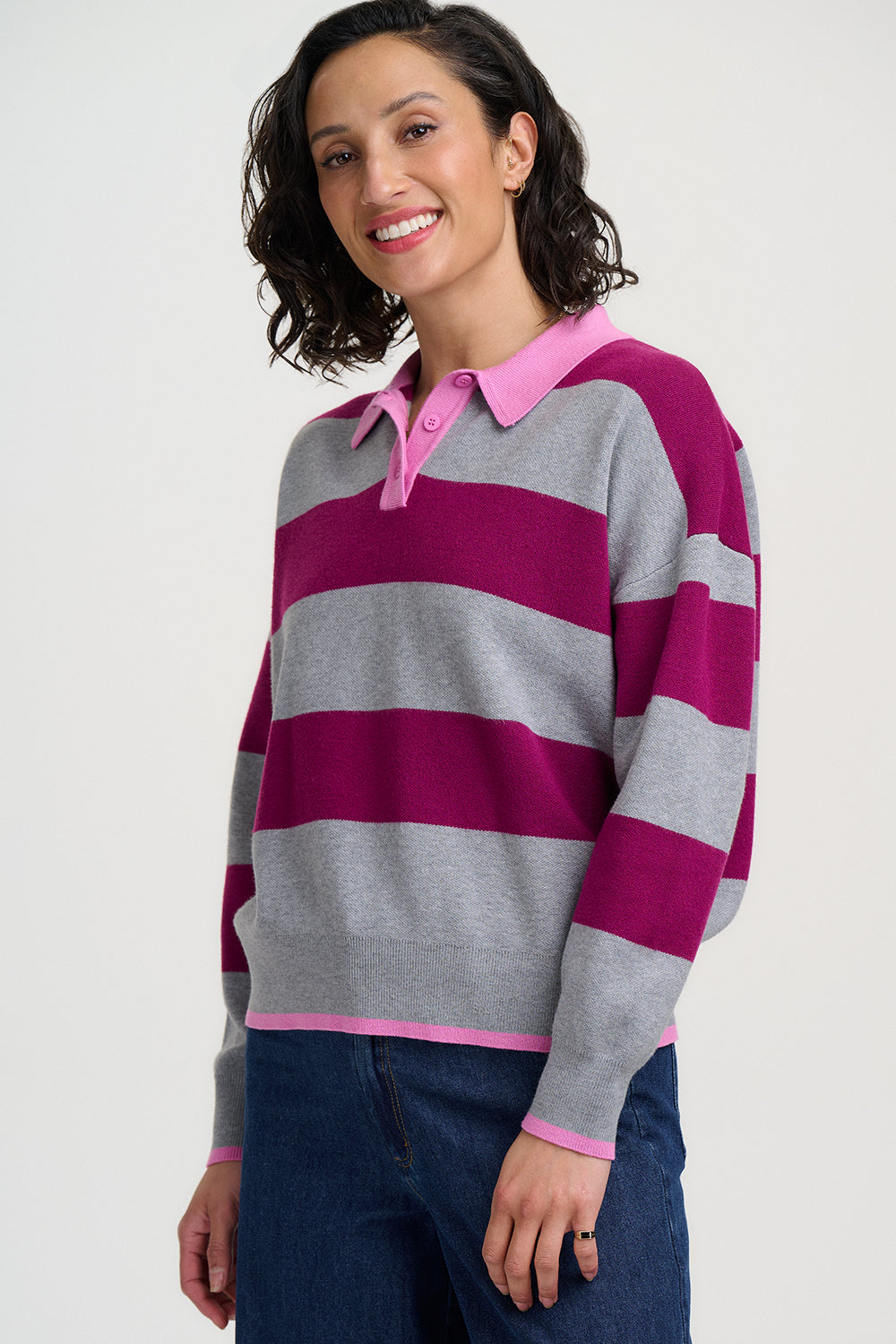 Woman wearing a striped sweater with pink and gray colors on a white background