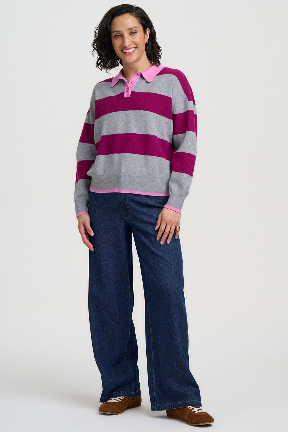 Woman wearing a striped sweater and jeans on a white background