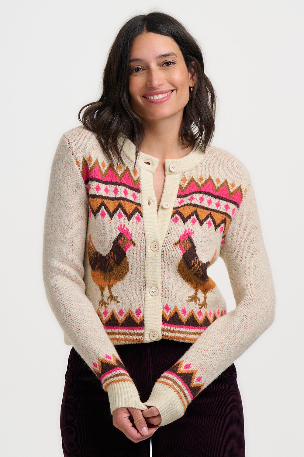 Woman wearing a patterned cardigan with rooster design on a white background