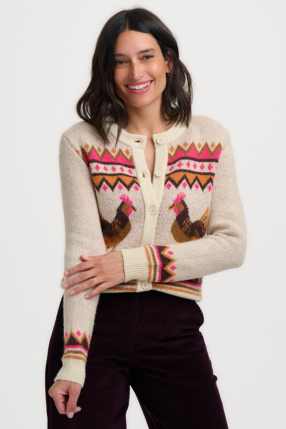 Woman wearing a cream cardigan with chicken pattern on a white background