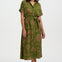 Woman wearing a green patterned dress on a white background