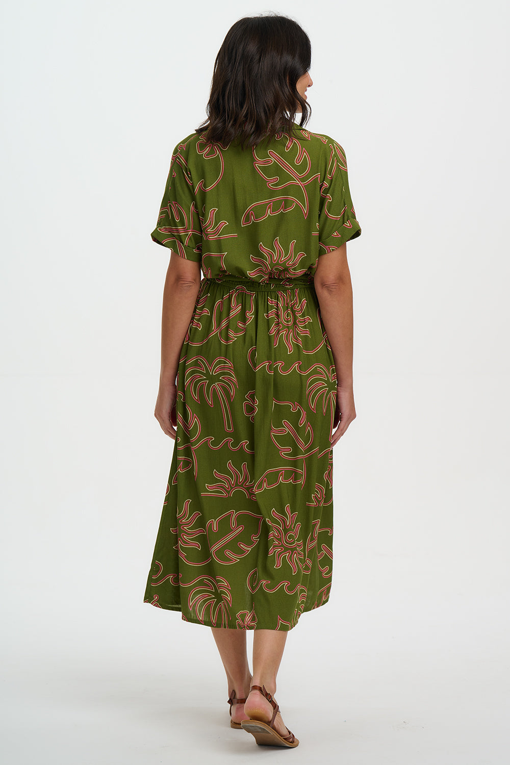 Woman wearing a green dress with floral pattern on a white background
