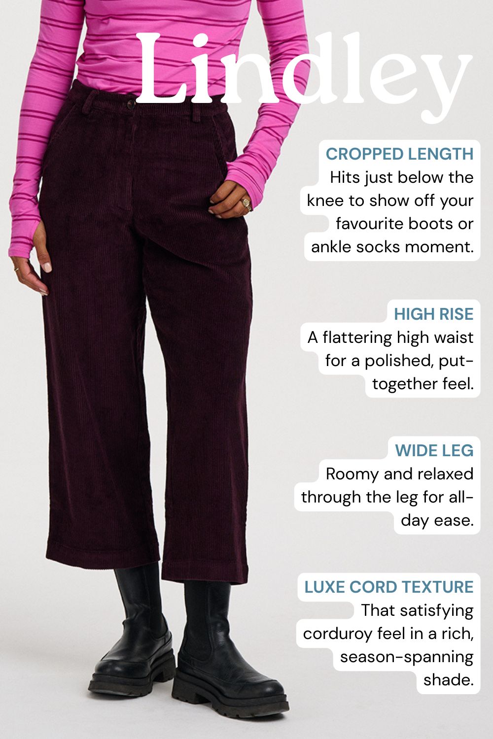 A model wearing Lindley cropped wide-leg corduroy trousers in a rich burgundy shade, styled with a pink striped long-sleeve top and black boots. The image features descriptive text callouts highlighting the cropped length, high rise, wide leg, and luxurious corduroy texture.