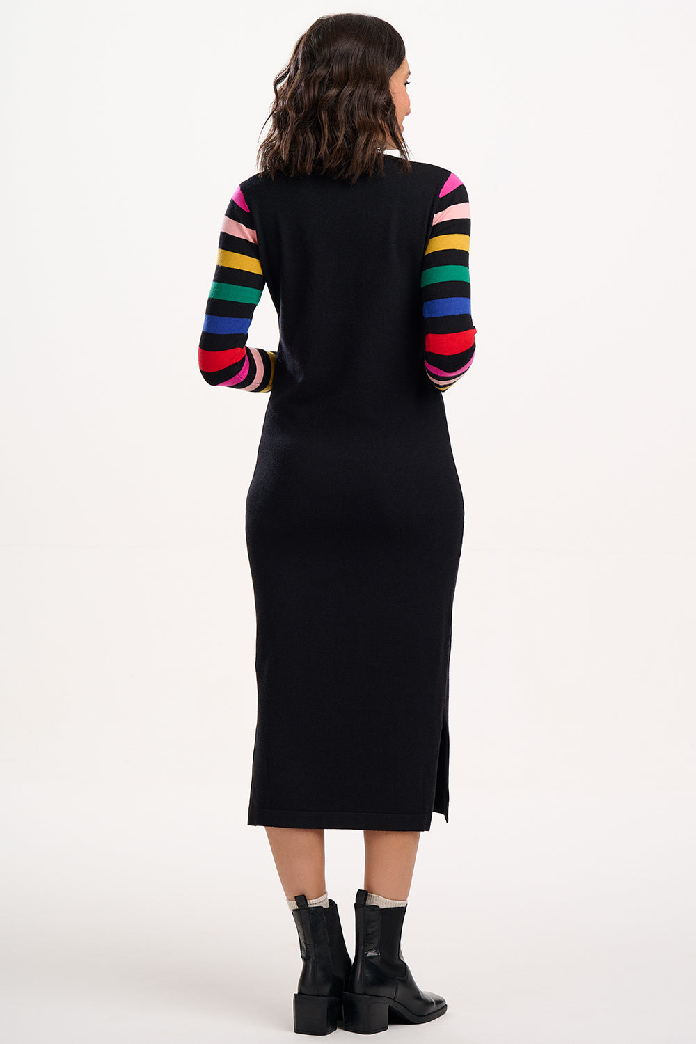 Black dress with colorful sleeves worn by a person on a white background