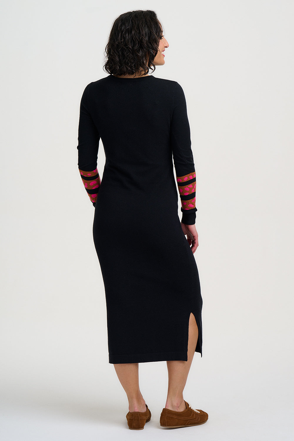 Woman wearing a black dress with red and black striped sleeves on a white background