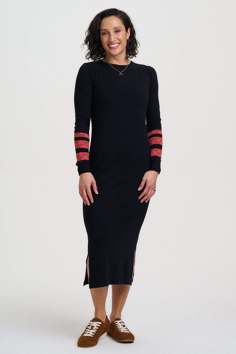Woman wearing a black dress with red and gold accents on a white background