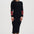 Woman wearing a black dress with red and gold accents on a white background