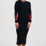Woman wearing a black dress with red and gold accents on a white background