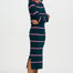 Woman wearing a green and pink striped dress with a white background