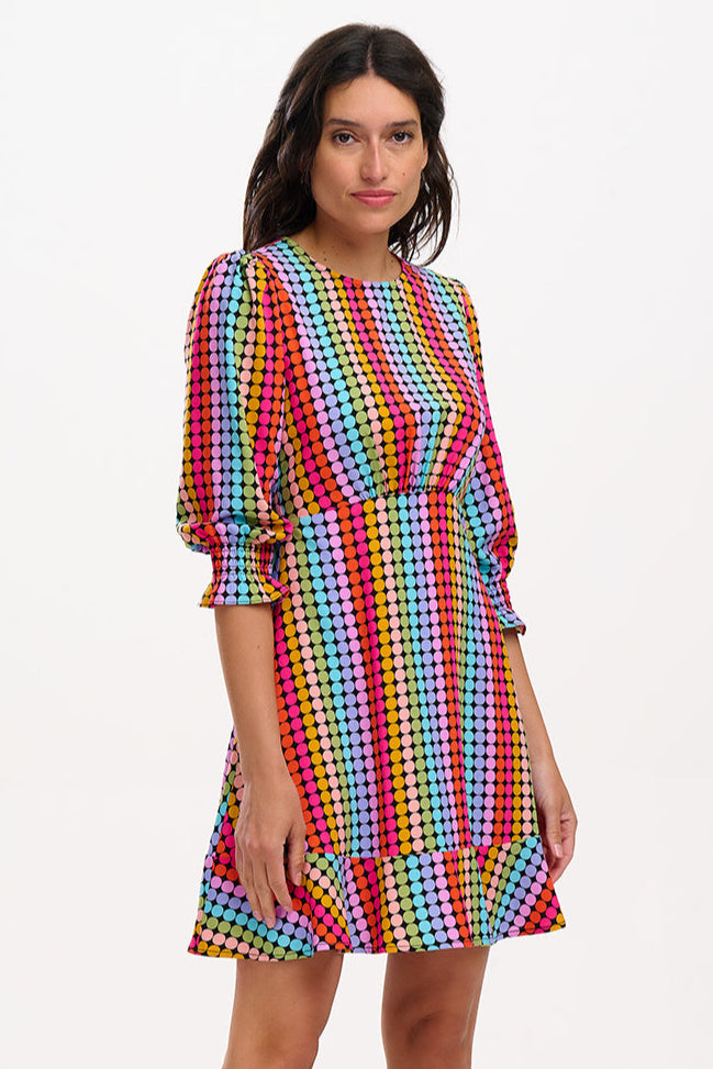 Woman wearing a colorful polka dot dress on a white background