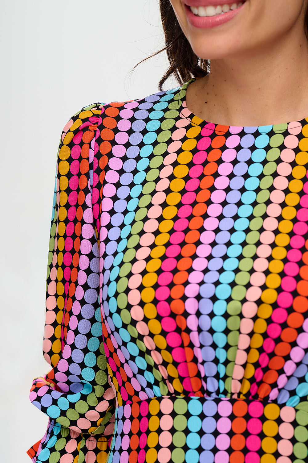 Woman wearing a colorful polka dot dress on a white background