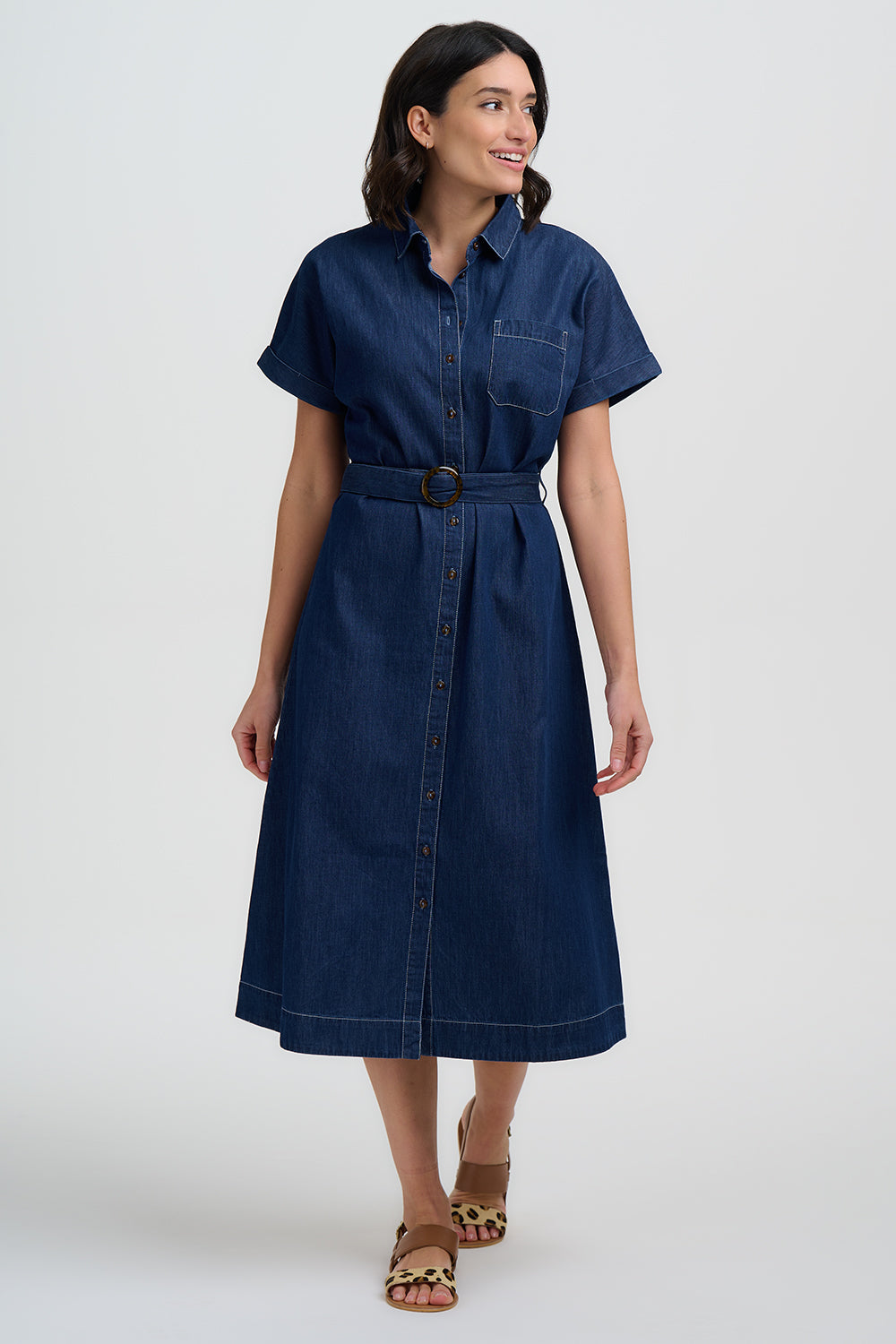 Woman wearing a blue dress with a belt on a white background