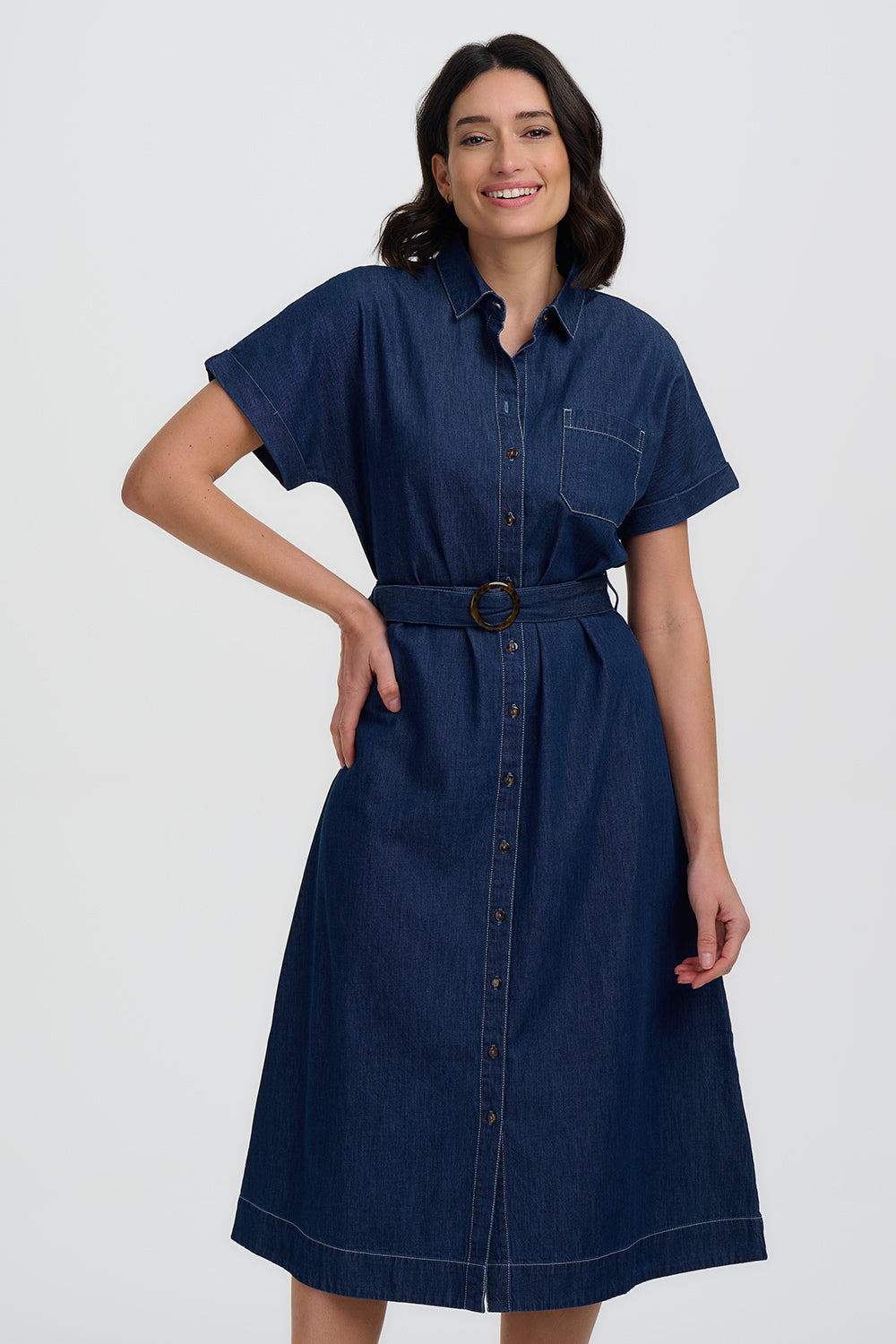 Woman wearing a blue denim dress with a belt on a white background