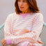 Woman wearing a pink and yellow striped sweater with blue jeans on a white background