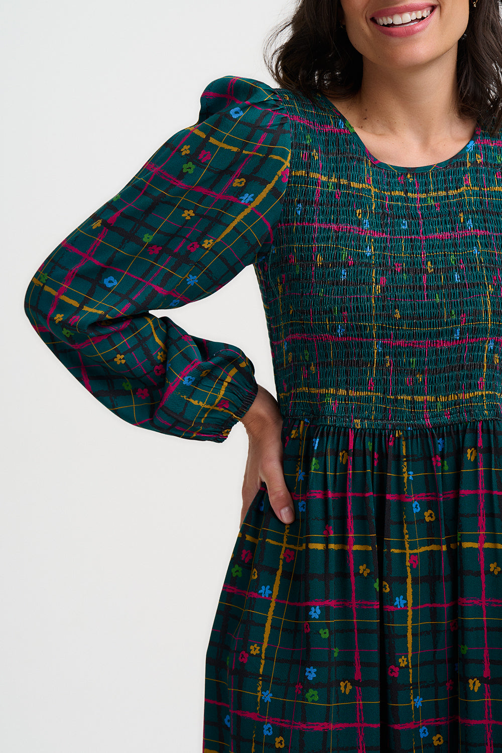 Woman wearing a plaid dress with colorful patterns on a white background