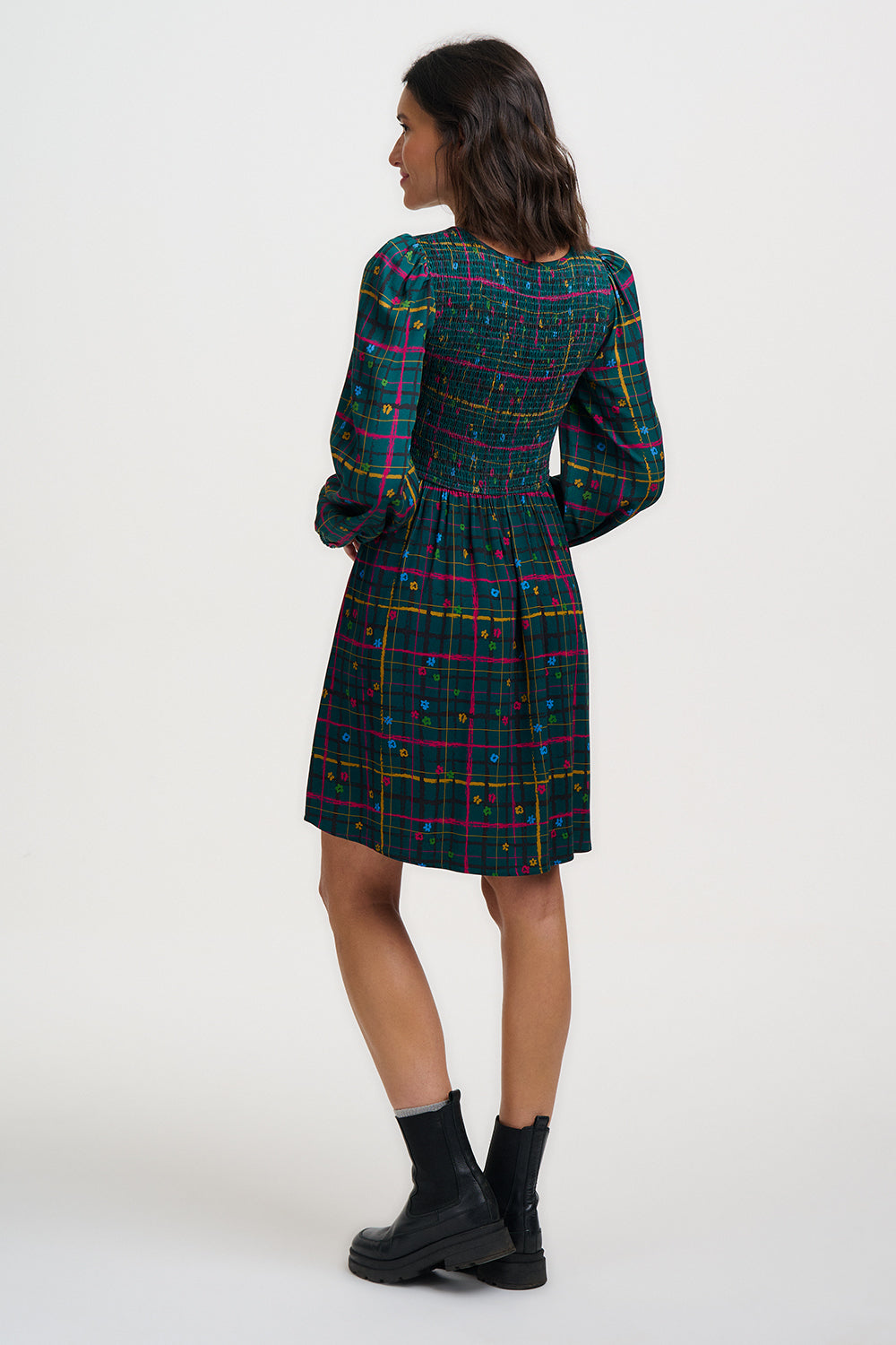 Woman wearing a plaid dress with a white background