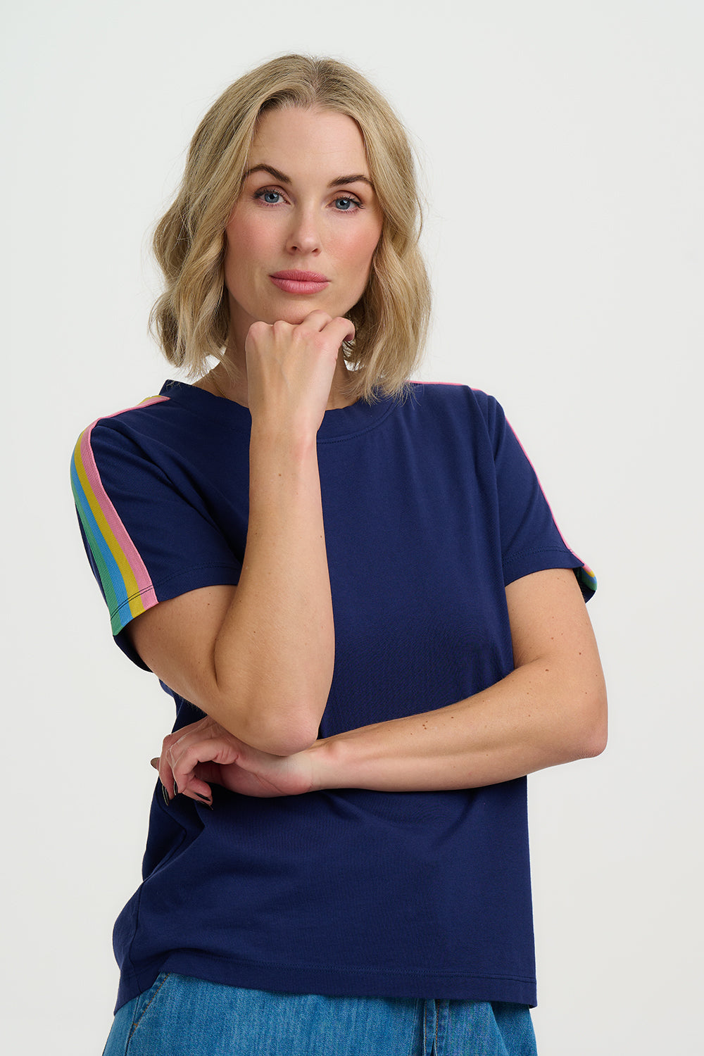 Woman wearing a navy blue t-shirt with colorful sleeves on a white background