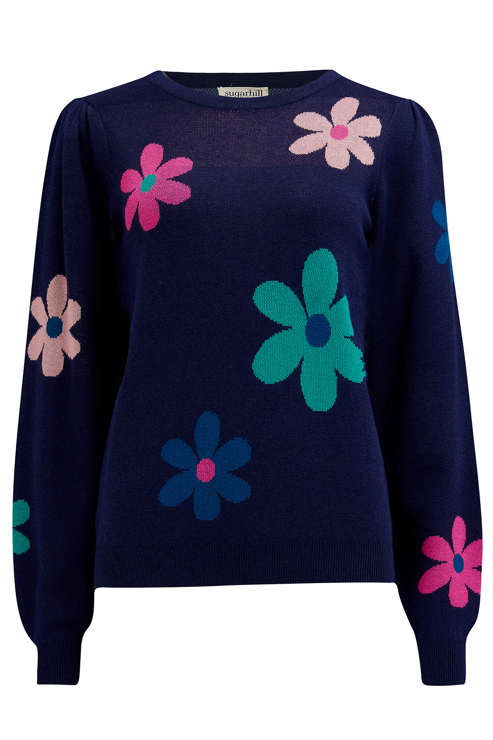 A navy blue jumper with a floral pattern consisting of large flowers in pink and green, paired with jeans.