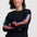 Woman wearing a black sweater with colorful stripes on a white background