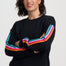 Woman wearing a black sweater with colorful stripes on a white background