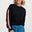 Woman wearing a black sweater with pink sleeves and blue jeans on a white background