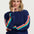Woman wearing a navy sweater with colorful sleeves against a white background