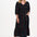 Sugarhill Brighton model wearing a black dress with colourful patterns on a white background