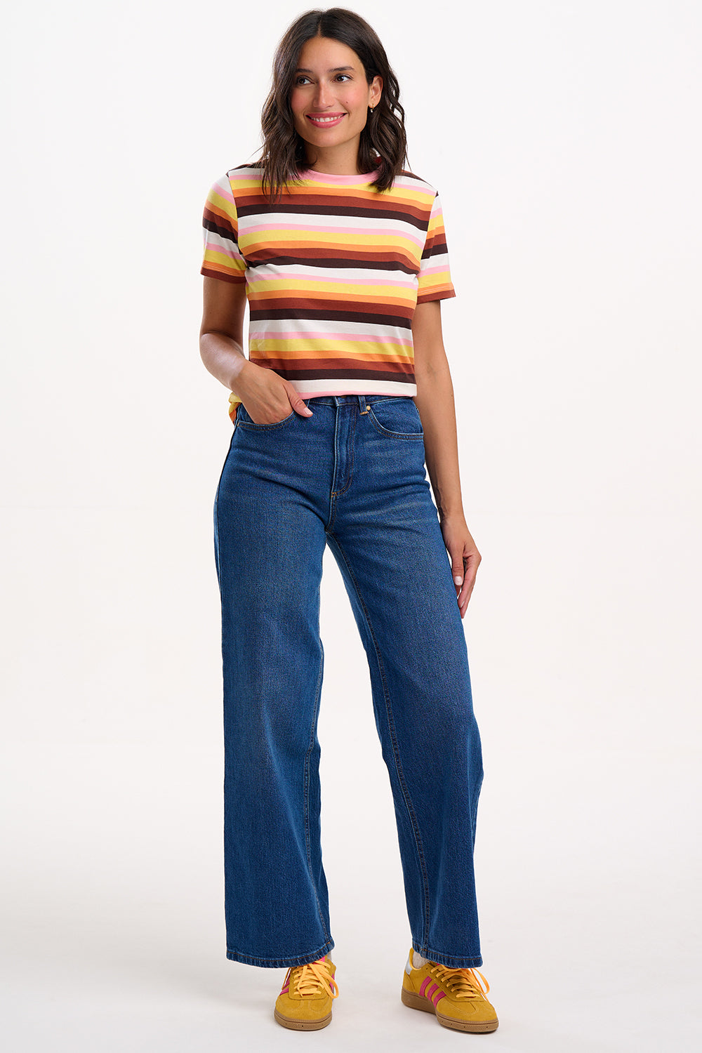 Sugarhill Brighton model wearing a striped shirt and blue jeans on a white background