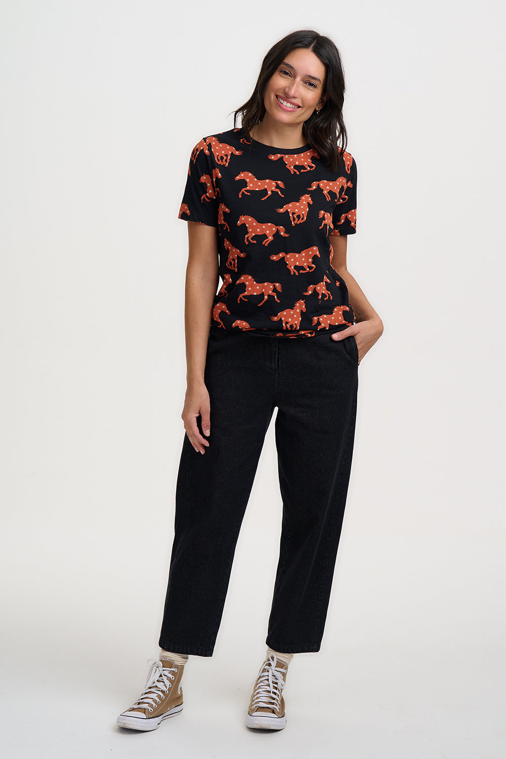 Woman wearing a black t-shirt with horse prints on a white background