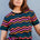 A woman modeling a black and multicolored wavy chevron stripe t-shirt.