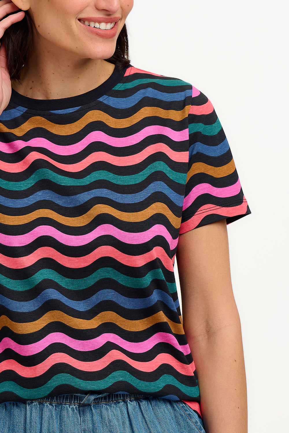 A model wearing a multicolored wavy chevron stripe t-shirt with a crew neck, in a black/multi color palette.