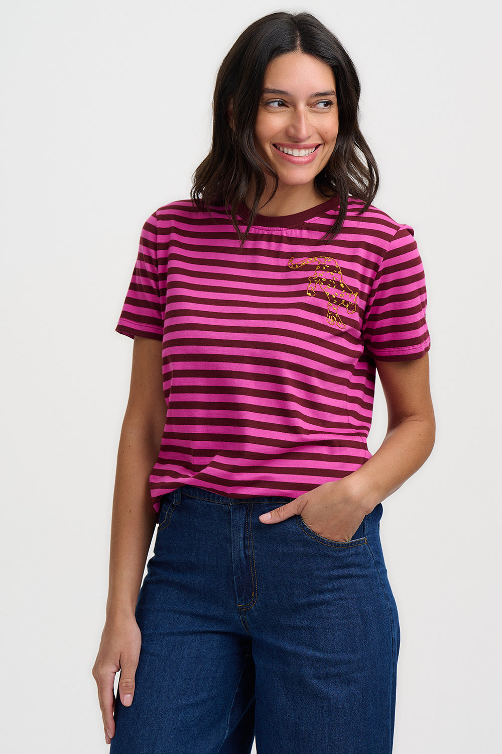 Woman wearing a pink and purple striped t-shirt with a leopard print design on a plain background