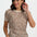 Woman wearing a leopard print top and blue jeans on a white background