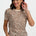 Woman wearing a leopard print top and blue jeans on a white background