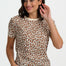 Woman wearing a leopard print top and blue jeans on a white background
