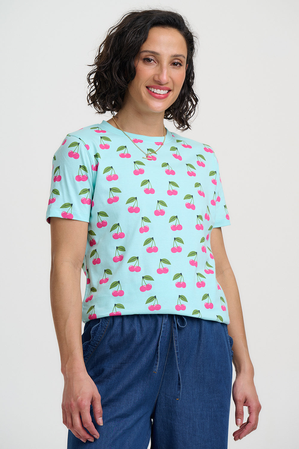 Light blue t-shirt with pink cherry pattern on a white background