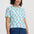 Light blue t-shirt with pink cherry pattern on a white background