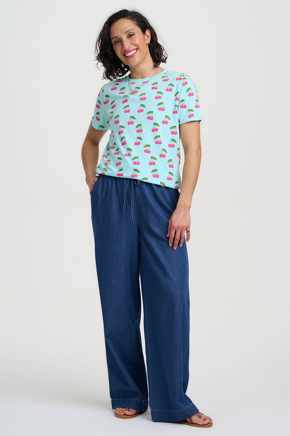 Light blue t-shirt with pink cherry pattern on a white background