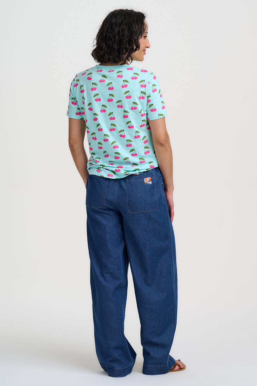 Light blue t-shirt with pink cherry pattern on a white background