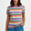 Woman wearing a colorful striped shirt and blue pants on a white background