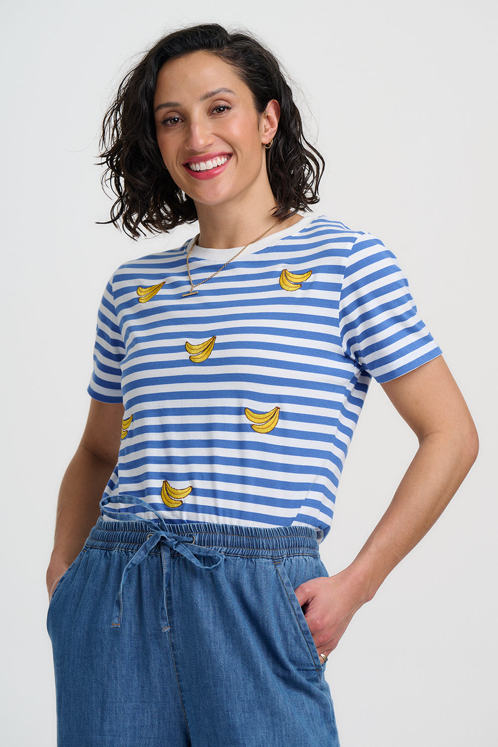Blue and white striped t-shirt with yellow banana prints on a plain background