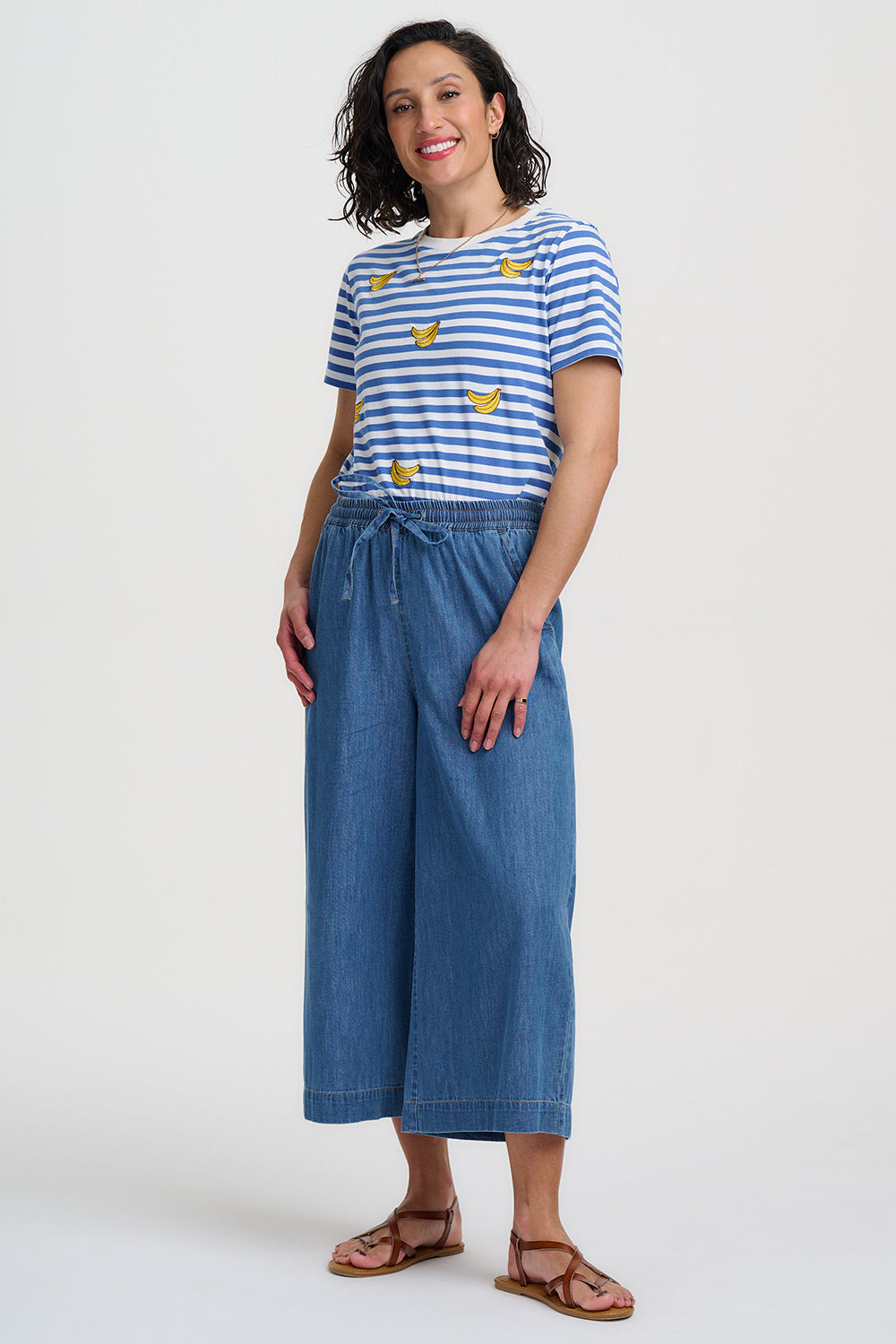 Blue and white striped t-shirt with yellow banana prints on a plain background