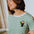 Person wearing a green and white striped t-shirt with a toucan design.